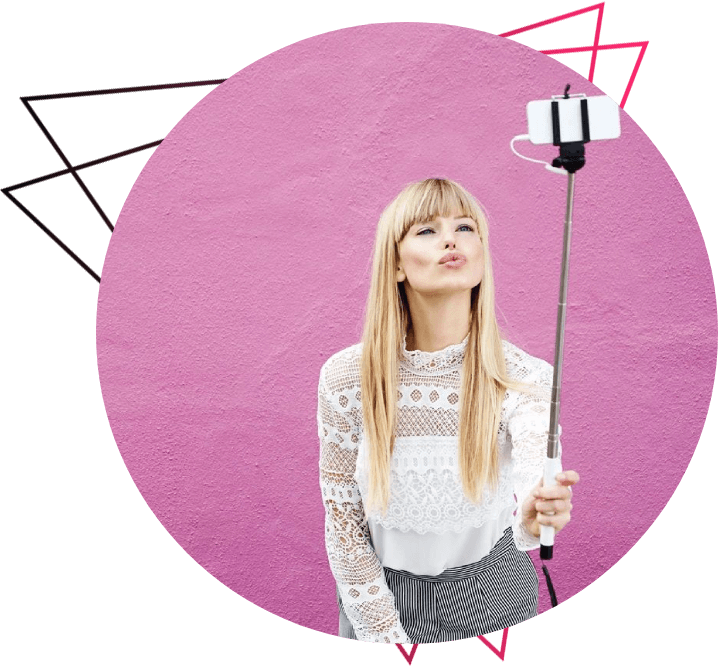 A woman holding a selfie stick in her hand.